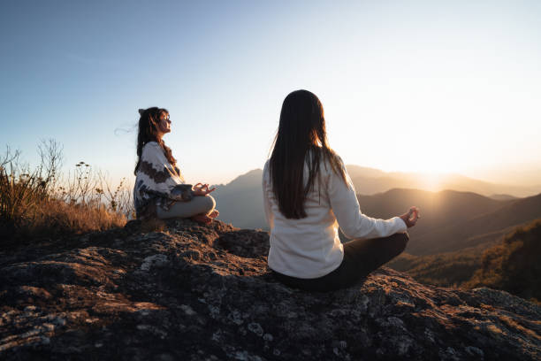 istock Women meditating in the mountains 1455601612