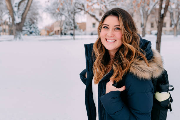 istock Close-Up Headshot of a Cheerful University Student Looking at Camera with a Backpack and Trendy Metal Water Bottle on Campus on a Snowy Day in Colorado 1455603688