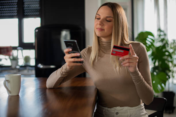 istock Cheerful  young woman doing online shopping 1455604887