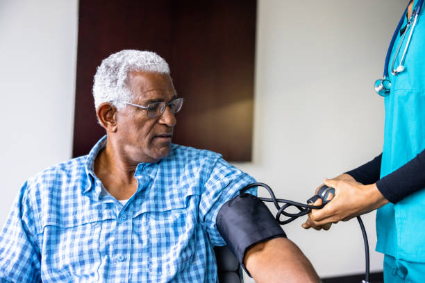 reunión de enfermera con un paciente negro de edad avanzada - blood pressure bulb fotografías e imágenes de stock