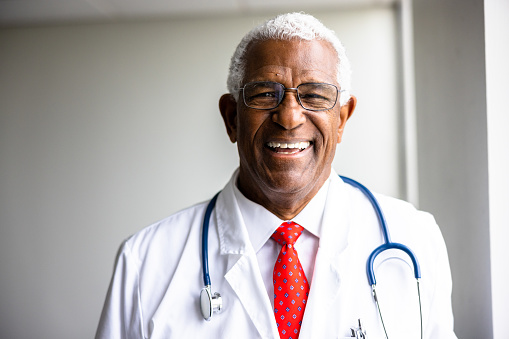 A senior black doctor looking at the camera