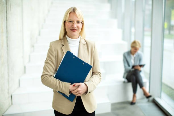 istock Young businesswoman standing with file folder and posing 1455610917