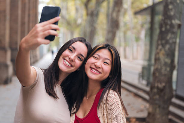 istock women smiling and having fun taking a selfie 1455611409