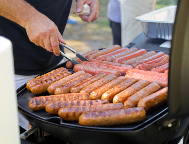 l’homme grillant des saucisses à l’extérieur, pique-d’été, photos macro - barbecue grill chef barbecue sausage photos et images de collection
