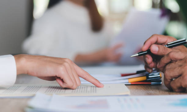 istock Broker pointing at documents for clients to sign, handling business documents and agreements business contract signing Approval of contract or warranty documents,investment loan approval 1455631907