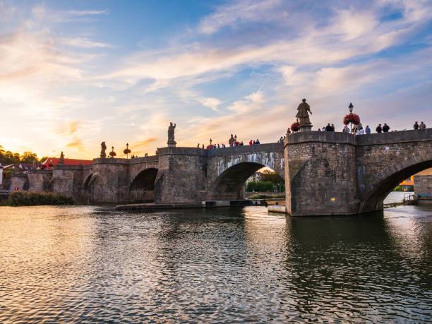 istock Image of an Old Main Bridge on the river under the cloudy sunset sky. 1455636521