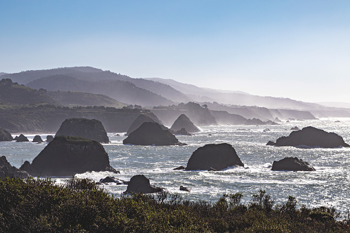 Rocks are incredibly prominent in the coastal Highway 1 by the Mendocino coast. The Pacific Ocean is seen here, with a beach cove.