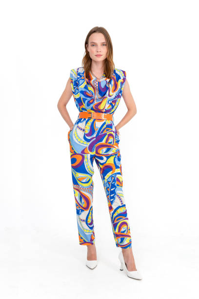 istock Blonde girl on a white background, wearing a multi-colored and patterned short sleeved blouse and trousers. 1455643459