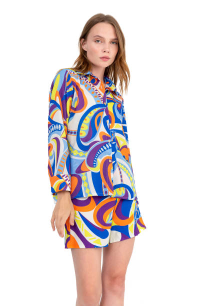 istock Blonde girl on a white background, wearing a multi-colored and patterned shirt and shorts. 1455643584