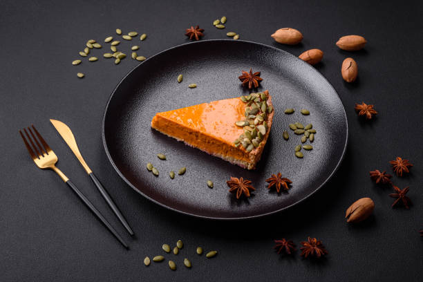 istock Beautiful tasty pumpkin pie with seeds on a black ceramic plate 1455651348