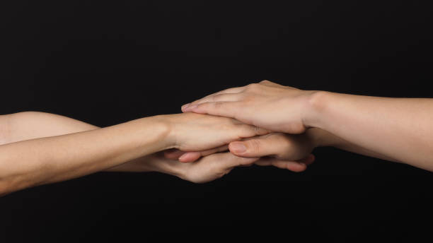 istock Hands, solidarity and teamwork .Unity or agreement of feeling on black background. 1455655711