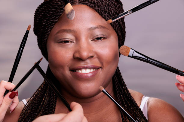 istock Makeup artist hands applying decorative cosmetics on woman face 1455659076