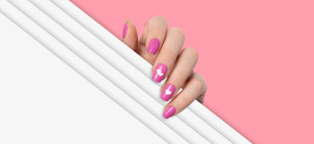 istock Female hand with pink manicure nails. Hearts design 1455660763