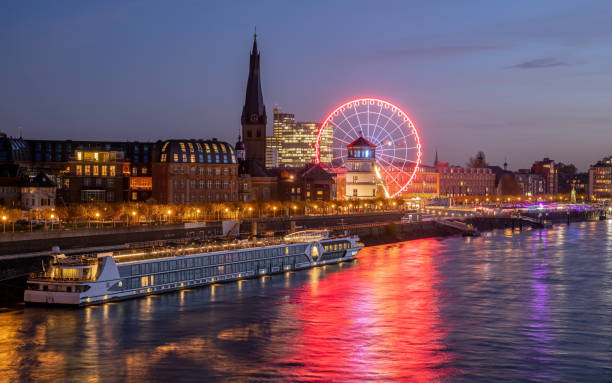 Düsseldorf, Germany - November 24, 2022: Wheel of vision and historic castle tower during sunset on November 24, 2022 in Dusseldorf, Germany