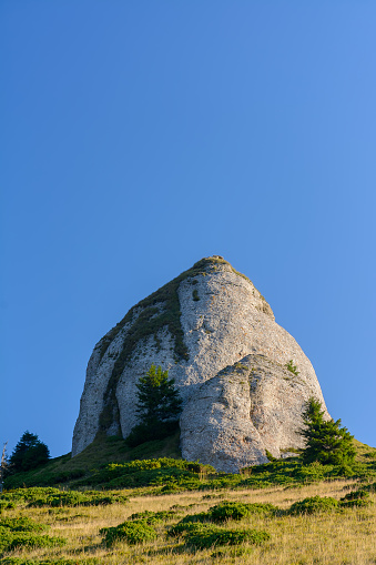 Strange looking mountain peaks landscape in Ciucas mountains, Romania, rising high, blue sky background. Natural alpine stone cliffs emerge from the grassy mountain slopes, isolated for photomontage