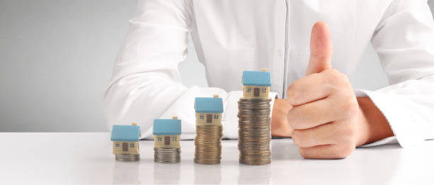 istock House Residential Structure in hand ,model house and coin 1455663687
