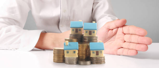 istock House Residential Structure in hand ,model house and coin 1455663693