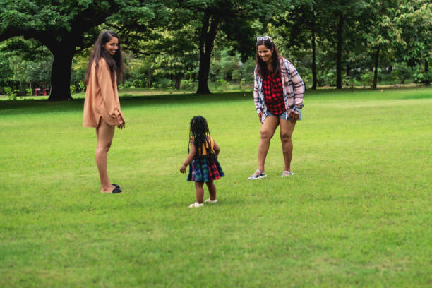 African baby girl trying to standing and walking by herself in public park