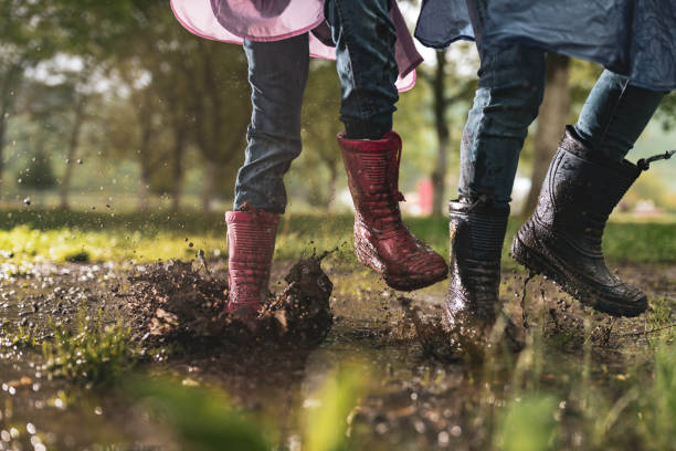 istock Unrecognizable kids running through muddy puddle in nature. 1455663791