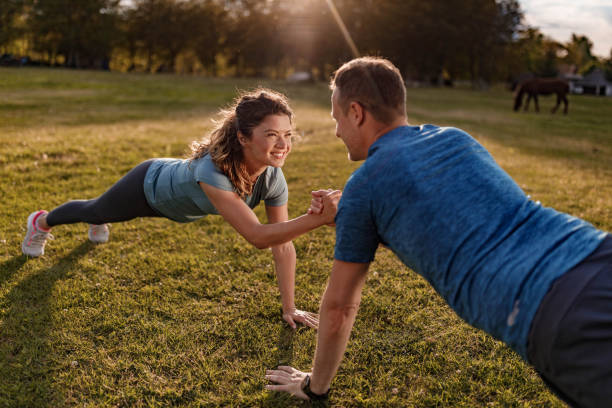 istock Happy athletic couple cooperating while exercising strength in nature. 1455664537