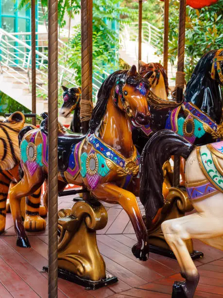 Photo of old carousel with horses in the amusement park