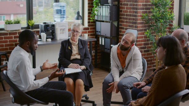 istock Multi ethnic people having discussion about addiction at a group therapy 1455669201
