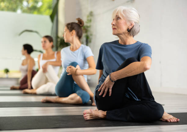 Group of sporty people practicing various yoga positions during training stock photo