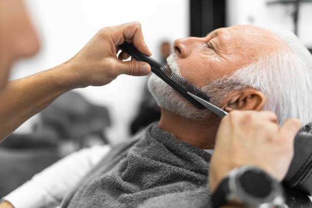 istock Senior man at barber styling his beard 1455669563