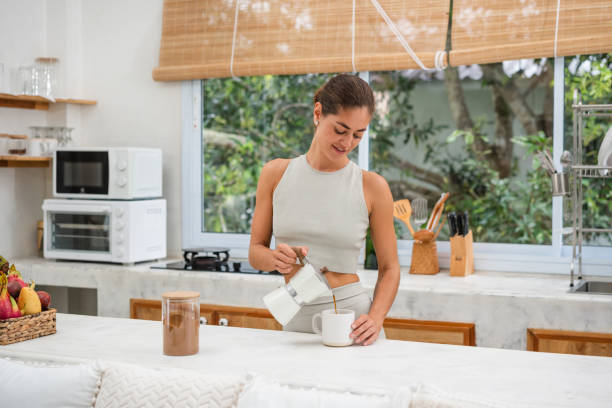 istock Smiling woman pouring coffee into a cup 1455672270