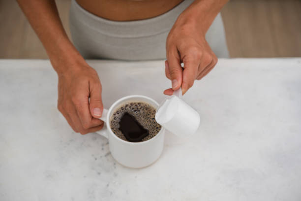 Couple in love holding hands with coffee on white wooden table. Photograph taken from above, top view with copy space