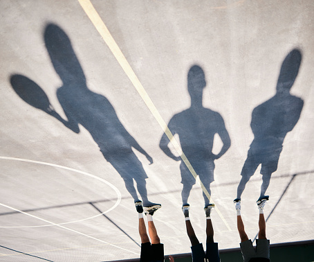 Basketball, shoes and silhouette of team upside down on basketball court training for game or competition. Fitness, sports and shadow of basketball players ready for exercise, workout or practice.