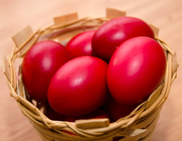 istock Closeup of red Easter eggs in a basket on a wooden table 1455674330