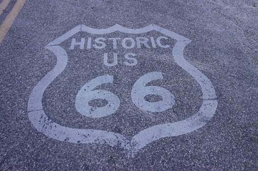 A closeup of a historic ROUTE 66 sign printed on a concrete road
