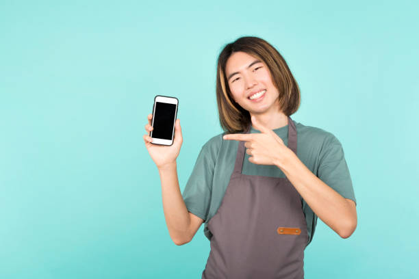 istock Asian man pointing to the blank screen of a mobile 1455676952