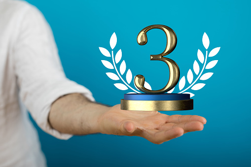 A 3d rendering of the third-ranked award with a design in a man's hand