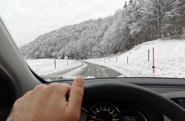 istock View from the car on a snowy road with trees 1455678870