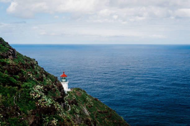 istock Small lighthouse on a rocky cliff against the ocean 1455679397