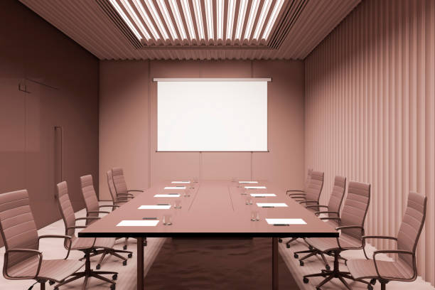 istock Front view on blank white poster with place for your logo or text on brown wall in conference room with led lamps on top an big meeting table surrounded by office chairs. 3D rendering, mock up 1455679403