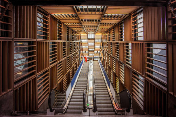 A view of the modern and futuristic subway station architecture in Rotterdam, The Netherlands. This scene captures the sleek entrance to the Blaak subway station, featuring an underground corridor that serves both pedestrians and cyclists. The innovative design of Rotterdam Centraal station is also highlighted, showcasing the city's commitment to contemporary and functional urban infrastructure.