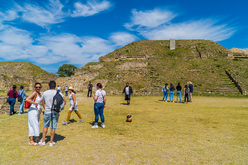 Monte Alban, Mexico – December 02, 2021: A lot of tourists visit pyramids and ancient Zapotec ruins inside Monte Alban Archaeological Zone