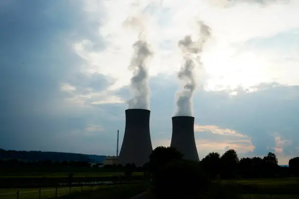 A nuclear power plant in Grohnde with cooling towers and surrounding landscape during an evening