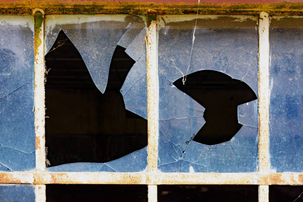 istock Broken dirty old glass of a grid window on vintage warehouse 1455684814