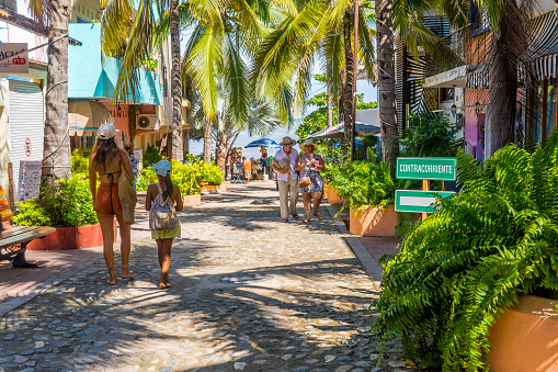 Sayulita, Mexico – October 13, 2021: A group of tourists in the magic town of Sayulita, Mexico with a beach in the background