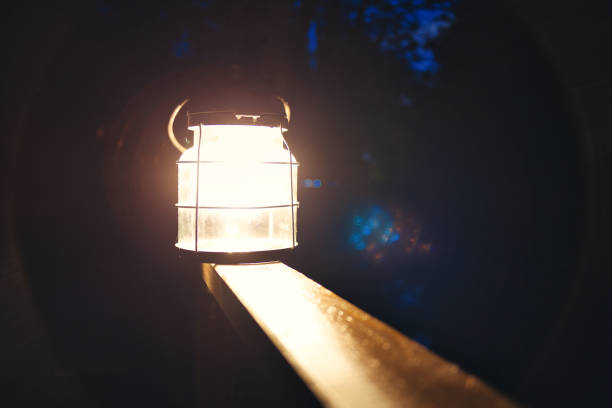 istock Old illuminated lantern on wooden board 1455687830