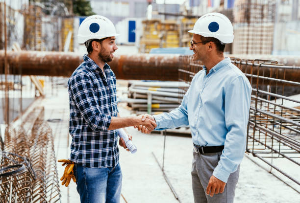 istock Engineers and investors on construction site. Manager and contractor shaking hands and smiling 1455689276