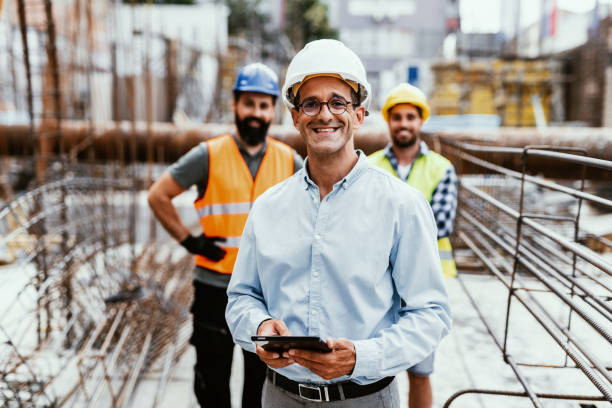 istock Engineers on construction site, looking at camera and smiling. Employment in housing and real estate sector 1455689914