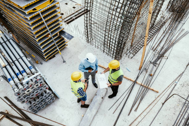 unrecognisable engineers on construction site, high angle view of employees in construction industry - bouwbedrijf stockfoto's en -beelden