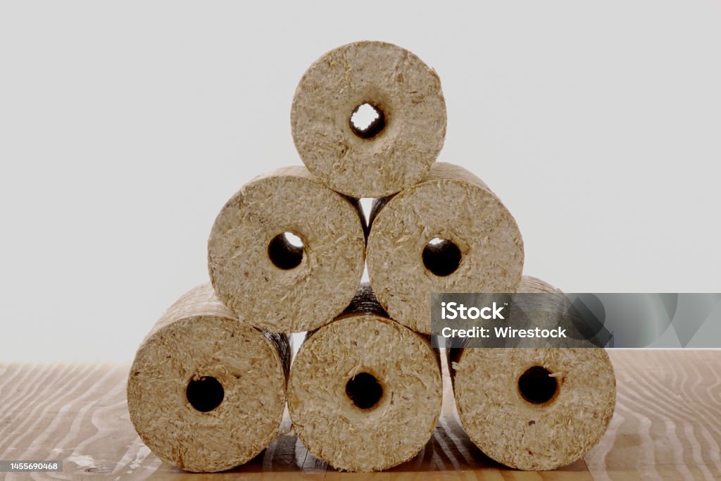 Round wooden briquettes on wooden beams isolated on a white background The round wooden briquettes on wooden beams isolated on a white background Circle Stock Photo