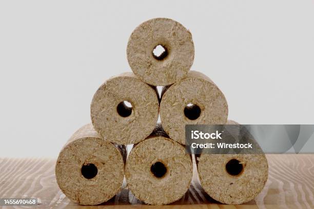 Round Wooden Briquettes On Wooden Beams Isolated On A White Background Stock Photo - Download Image Now