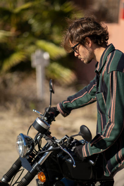 istock Handsome guy near a motorcycle motorist posing in fancy clothes 1455692039